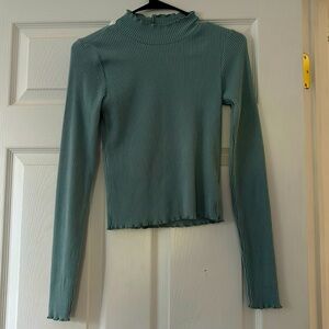 Turtle neck. Has frills by sleeve, the neck, and the waist. Very good condition.